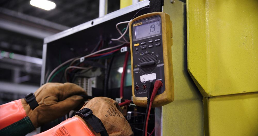 Électricien mesurant la tension avec un multimètre dans un tableau